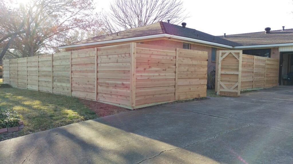 A wooden shed sitting in the middle of a driveway.