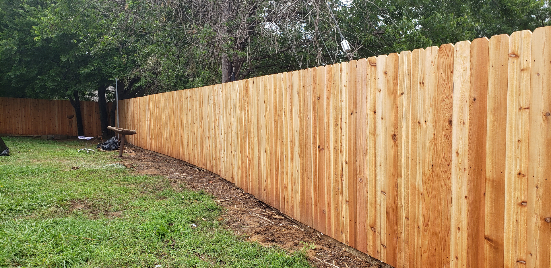 A wooden fence with grass in the foreground.