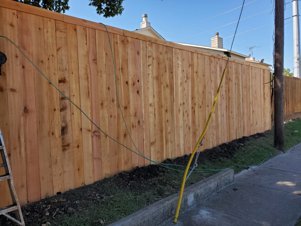 A wooden fence with yellow tape on it.